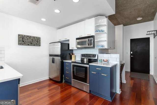 kitchen with appliances with stainless steel finishes, dark hardwood / wood-style floors, tasteful backsplash, white cabinets, and blue cabinets