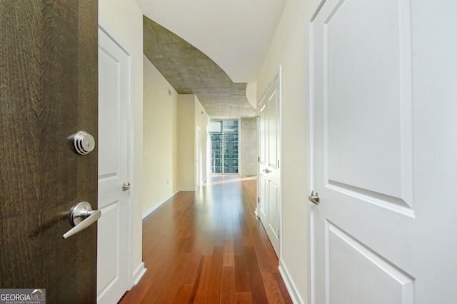 corridor with dark hardwood / wood-style flooring