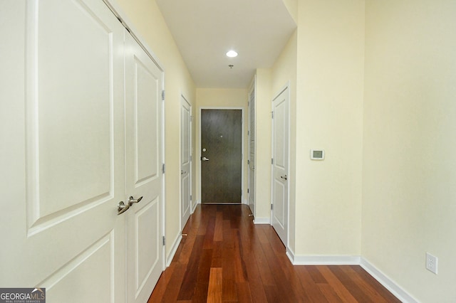 corridor with dark hardwood / wood-style flooring