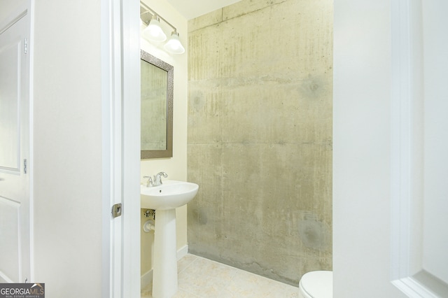 bathroom featuring toilet, tile patterned floors, and sink