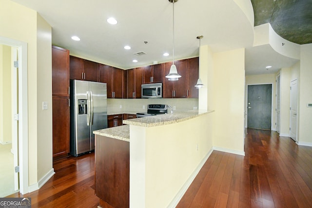 kitchen featuring stainless steel appliances, tasteful backsplash, dark hardwood / wood-style flooring, kitchen peninsula, and pendant lighting