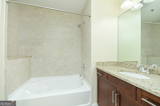 bathroom featuring vanity and tiled shower / bath