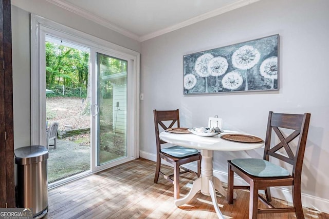 dining room with light hardwood / wood-style floors and ornamental molding