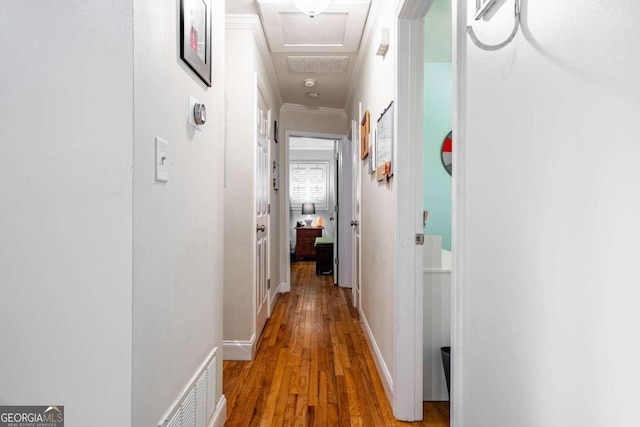 corridor featuring hardwood / wood-style flooring and crown molding