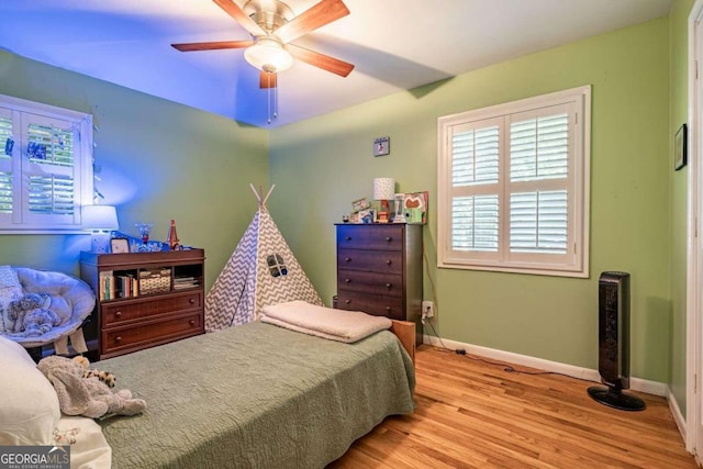 bedroom with light hardwood / wood-style flooring and ceiling fan