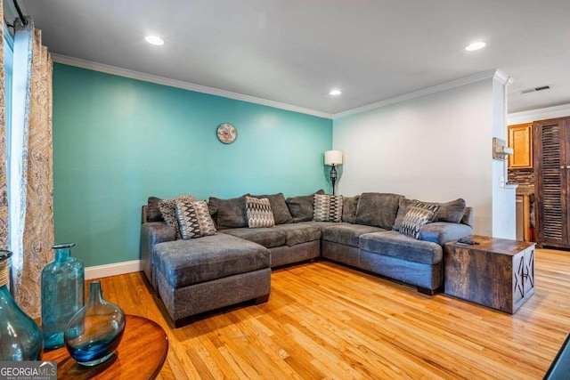 living room featuring light wood-type flooring and ornamental molding