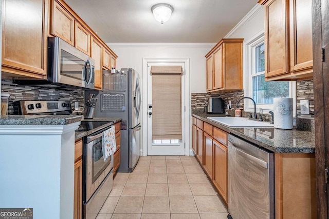 kitchen featuring sink, stainless steel appliances, tasteful backsplash, dark stone counters, and light tile patterned floors