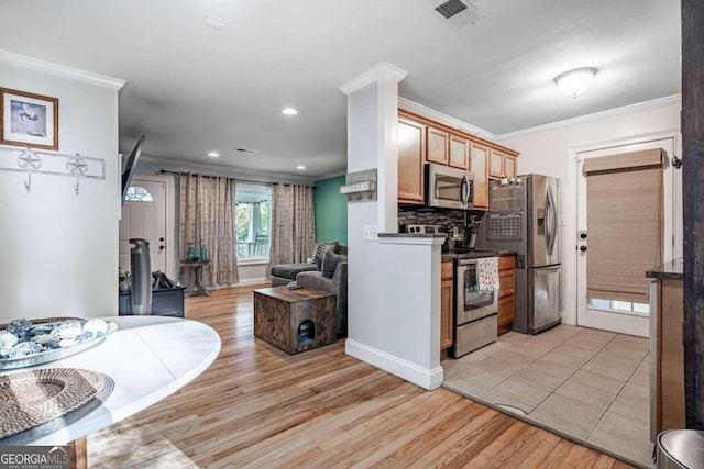 kitchen featuring appliances with stainless steel finishes, light wood-type flooring, crown molding, and backsplash