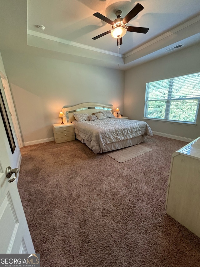 carpeted bedroom featuring a raised ceiling, ceiling fan, and crown molding