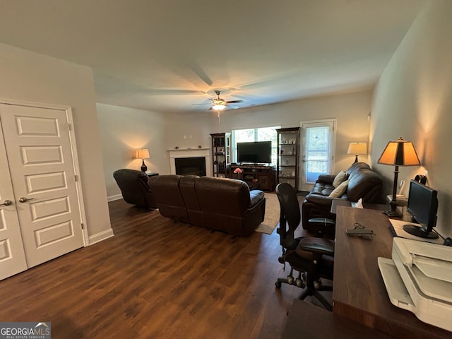 living room featuring ceiling fan and dark wood-type flooring