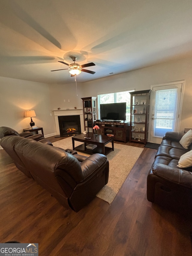 living room featuring ceiling fan and dark wood-type flooring