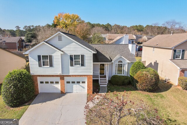 view of front of property with covered porch, a garage, and a front yard