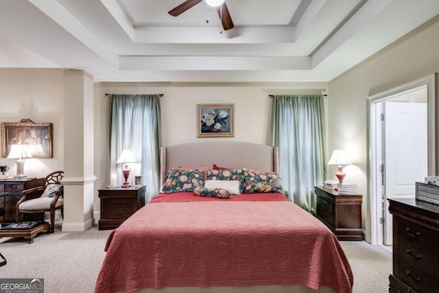 bedroom featuring ceiling fan, light carpet, and a tray ceiling