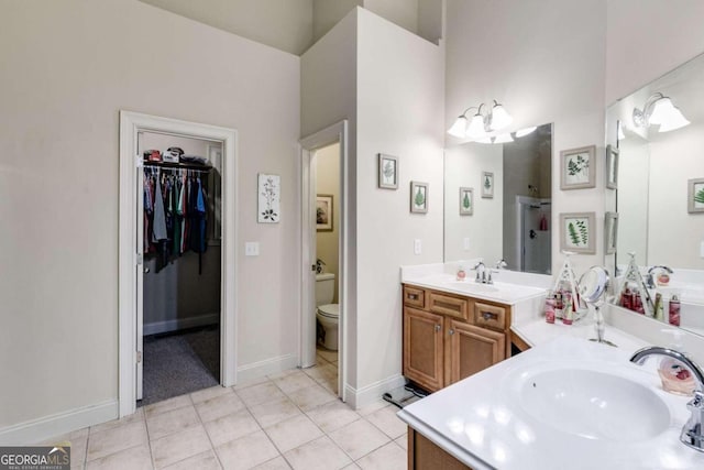 bathroom with toilet, a shower, vanity, and tile patterned floors