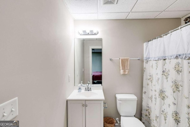 bathroom with vanity, a paneled ceiling, toilet, and a shower with shower curtain