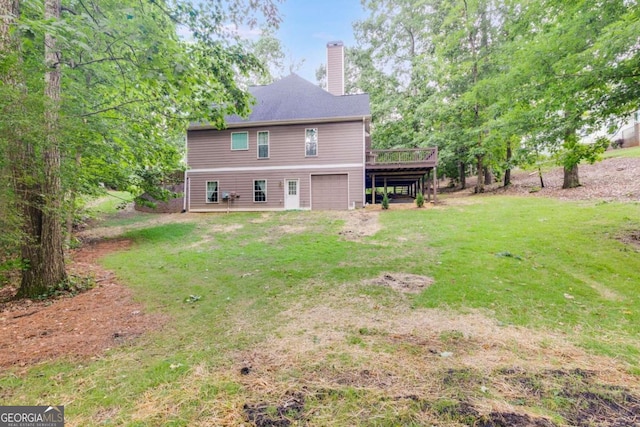 back of property with a garage, a deck, and a lawn