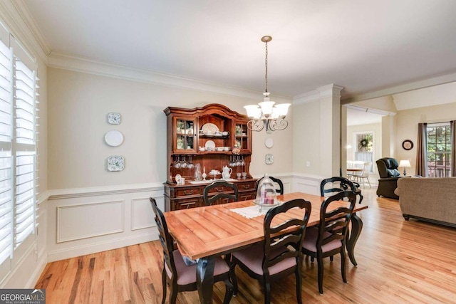 dining room featuring a notable chandelier, crown molding, and light hardwood / wood-style flooring