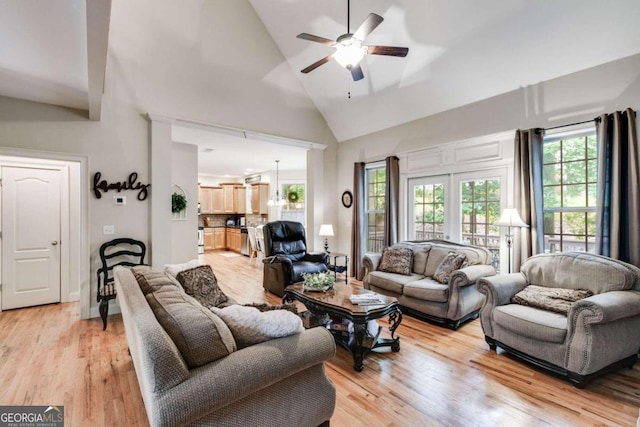 living room with ceiling fan, high vaulted ceiling, and light hardwood / wood-style floors