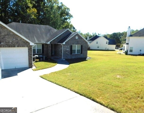 ranch-style house featuring a garage and a front lawn