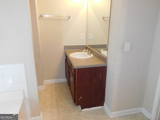 bathroom with a bathtub, tile patterned flooring, and vanity