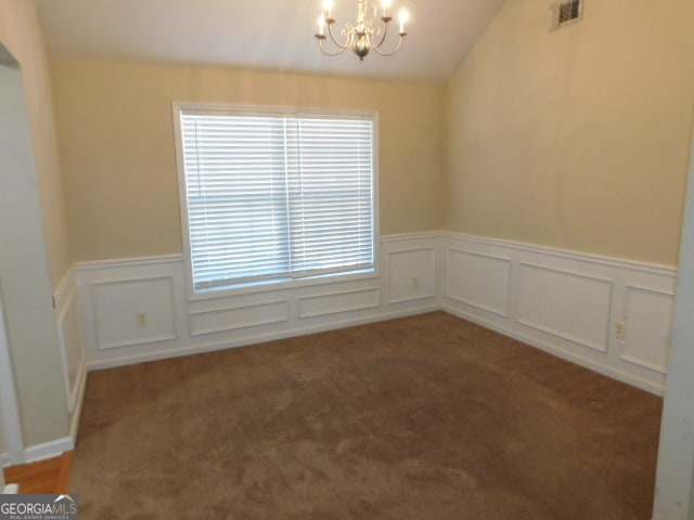 carpeted spare room with a chandelier and lofted ceiling