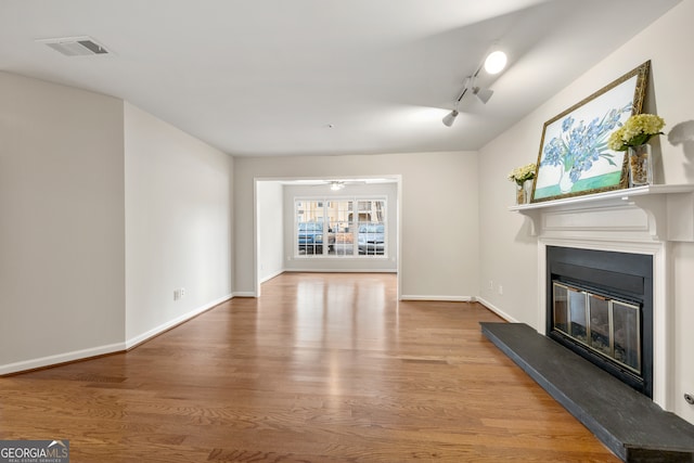 unfurnished living room featuring hardwood / wood-style floors and ceiling fan