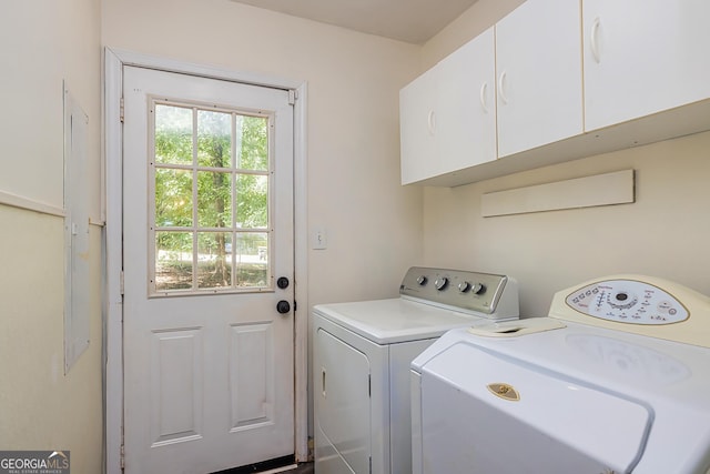 washroom with washing machine and clothes dryer and cabinets