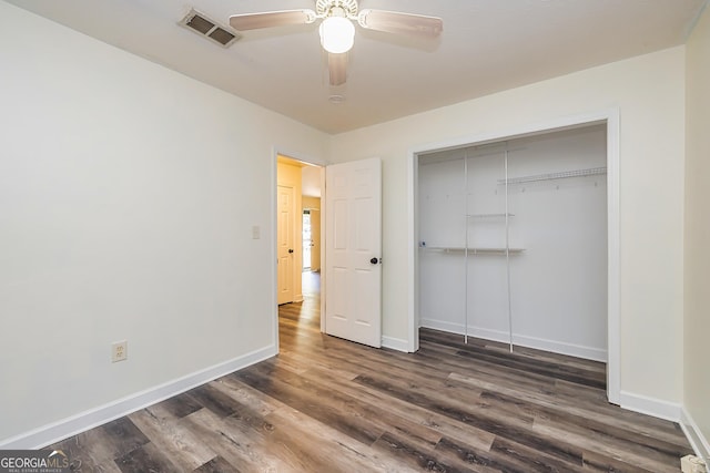 unfurnished bedroom with a closet, dark hardwood / wood-style floors, and ceiling fan