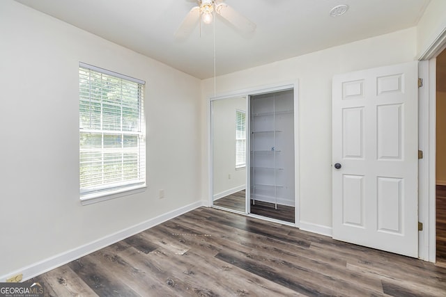 unfurnished bedroom featuring a closet, ceiling fan, and dark wood-type flooring