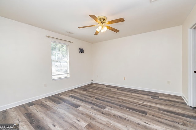 empty room featuring ceiling fan and dark hardwood / wood-style flooring