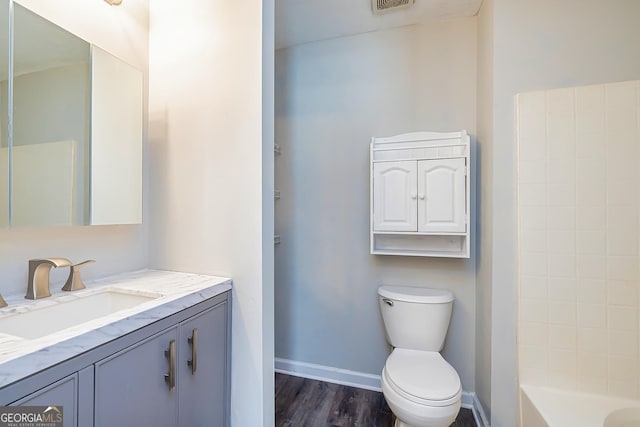 bathroom featuring wood-type flooring, vanity, and toilet