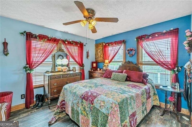 bedroom featuring multiple windows, hardwood / wood-style floors, a textured ceiling, and ceiling fan