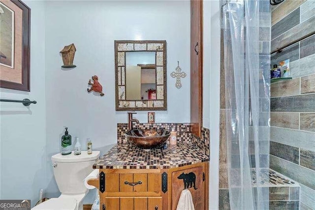 bathroom with a shower with shower curtain, vanity, and toilet