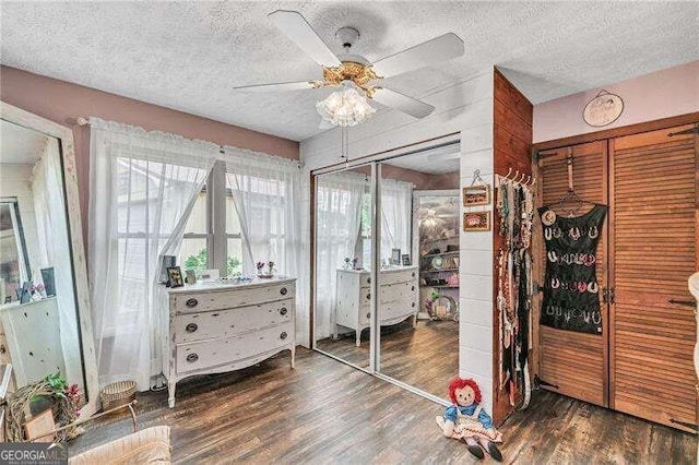 bedroom featuring ceiling fan, dark wood-type flooring, and a textured ceiling