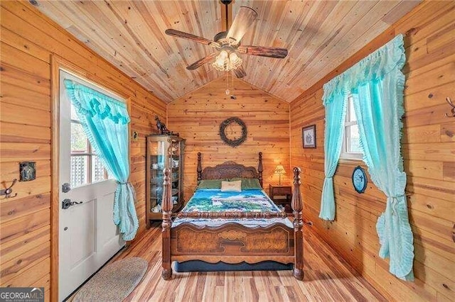 bedroom with hardwood / wood-style flooring, vaulted ceiling, wooden ceiling, and wood walls