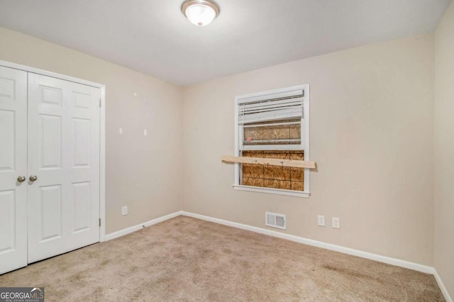 spare room featuring light colored carpet