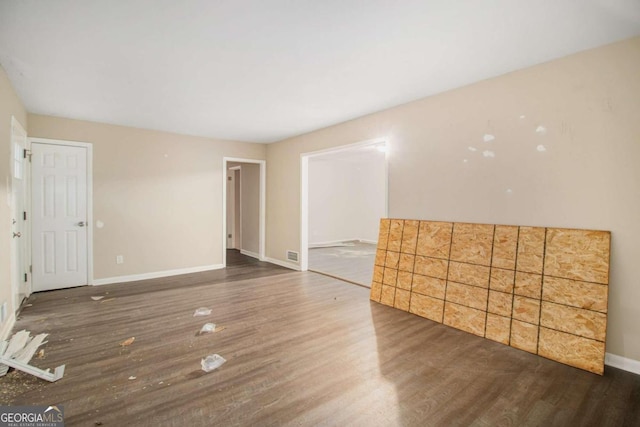 unfurnished room with dark hardwood / wood-style flooring