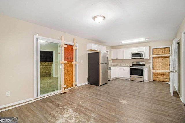 kitchen with white cabinets, stainless steel appliances, and dark hardwood / wood-style floors