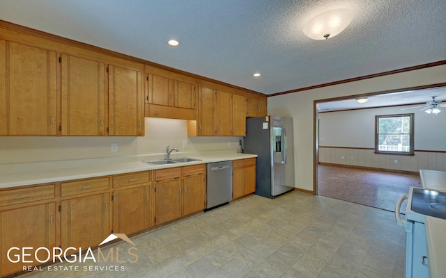 kitchen featuring appliances with stainless steel finishes, a textured ceiling, ceiling fan, crown molding, and sink