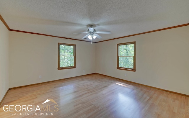 spare room with a wealth of natural light, light hardwood / wood-style floors, and a textured ceiling