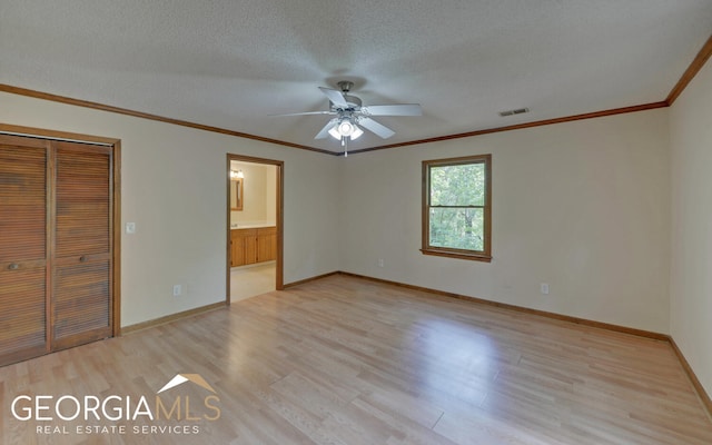 unfurnished bedroom featuring ceiling fan, crown molding, a textured ceiling, a closet, and light wood-type flooring