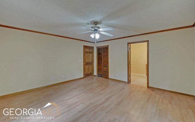 unfurnished room featuring ceiling fan, light wood-type flooring, a textured ceiling, and ornamental molding