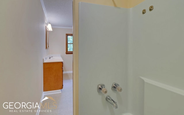 bathroom featuring a textured ceiling, vanity,  shower combination, and crown molding