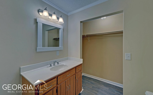 bathroom with vanity, crown molding, wood-type flooring, and a textured ceiling