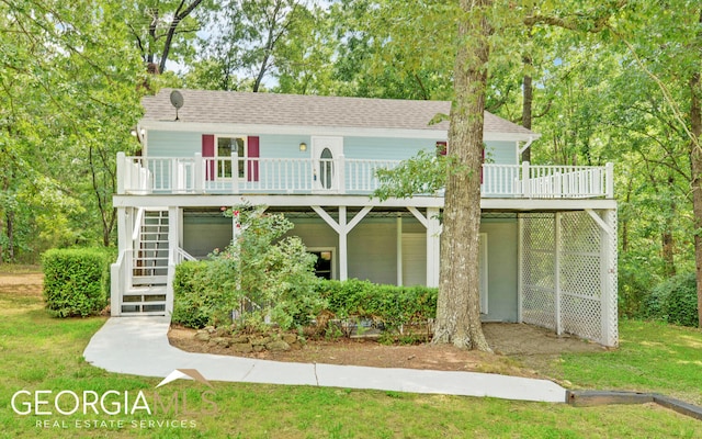 view of front of property featuring a wooden deck and a front yard