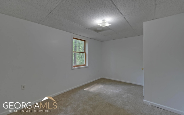 carpeted spare room with a paneled ceiling