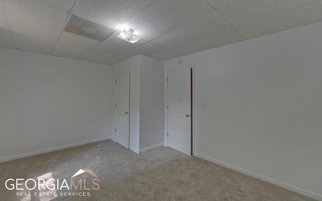 unfurnished room with carpet flooring and a paneled ceiling