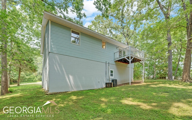 back of house with a wooden deck and a yard