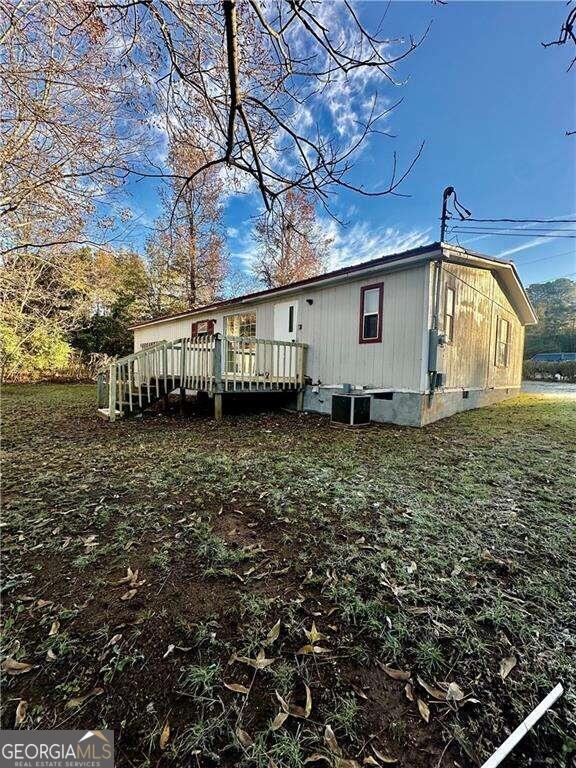 rear view of house with a wooden deck and central AC unit