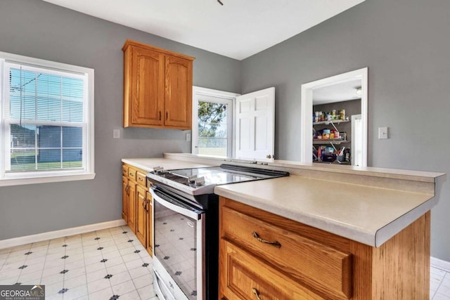 kitchen featuring electric range, a healthy amount of sunlight, and light tile patterned flooring